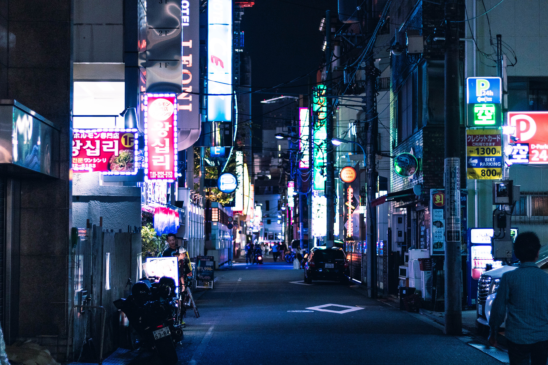 Street at night time with neon signs lining its edges.